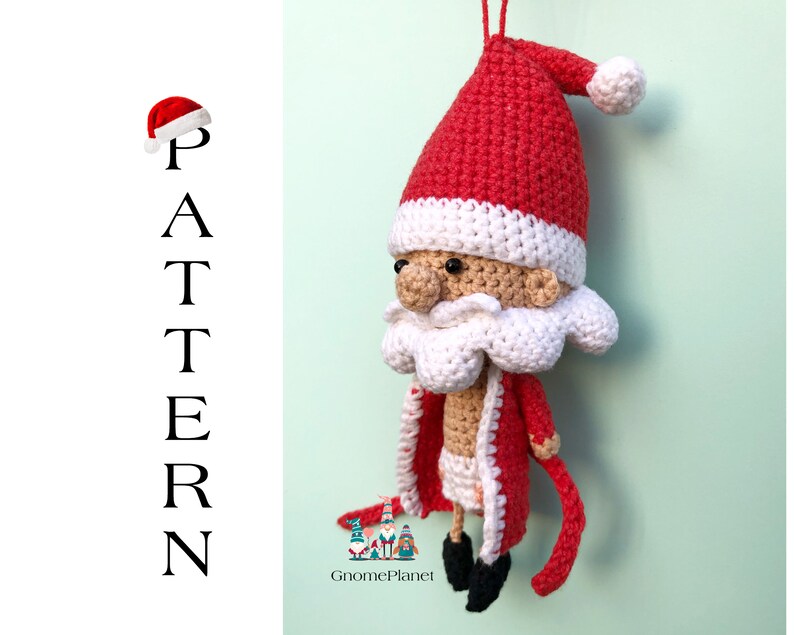 May include: Crocheted Santa Claus ornament with a red hat, white beard, and red and white coat. The ornament is hanging from a string and has a white background.