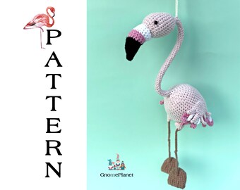 May include: A pink crocheted flamingo with black eyes and a white beak. The flamingo is standing on two brown legs and has a pink and white tail.
