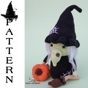 May include: Crocheted witch doll with a black hat, white hair, and a green face. The doll is holding a crocheted orange pumpkin. The doll is sitting on a green background.