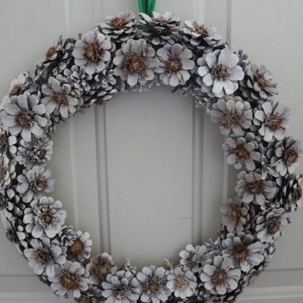 White Flower Pine Cone Wreath with a Green Satin Bow