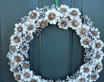 Couronne de fleurs faite main en pomme de pin : base en toile de jute, noeud en satin bleu