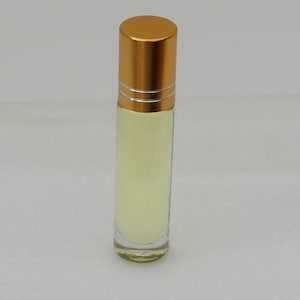 May include: A clear glass roller bottle with a gold metal cap and a gold metal band around the bottle. The bottle is filled with a light yellow liquid.