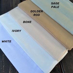 May include: Five fabric swatches in different shades of white, cream, and beige. The swatches are labeled from lightest to darkest: White, Ivory, Bone, Golden Rod, and Sage Pale.
