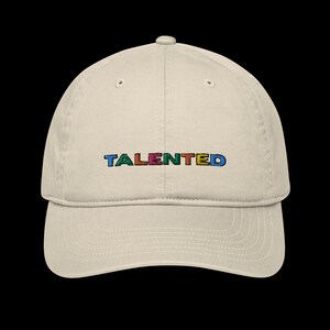 May include: A beige baseball cap with the word "TALENTED" embroidered in colourful letters.