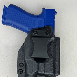 May include: A black plastic holster with a clip for a blue handgun. The holster has two screws on the side and a single screw on the bottom.