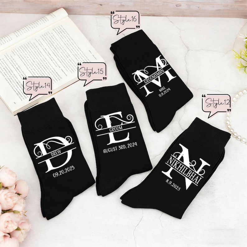 May include: Four black socks featuring white custom text and monograms. Each sock displays a large letter with a name and date printed underneath. The text includes DREW 09.20.2025, GROOM AUGUST 3RD, 2024, MIKE 11.9.2024, and NIKHILBHAI 8.9.2025, with style labels.