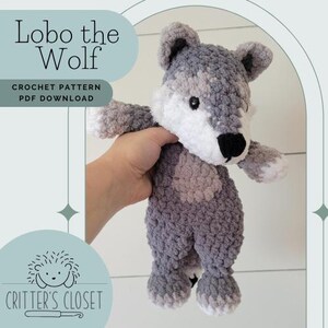 May include: A crocheted wolf plush toy named "Lobo the Wolf" in gray and white. The toy is being held by a hand. The image includes the text "Lobo the Wolf" and "Crochet Pattern PDF Download".