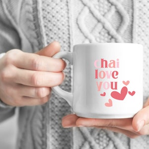 May include: White ceramic mug with the text "chai love you" in pink and red lettering. The mug is decorated with small pink and red hearts.