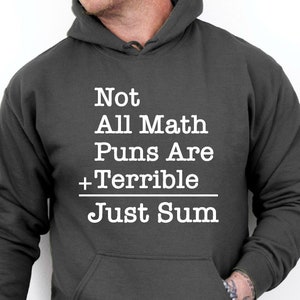 May include: Dark heather grey hoodie with a white graphic that reads "Not All Math Puns Are +Terrible Just Sum".