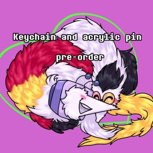 May include: A cartoon illustration of a white, black, red, and yellow creature with a smiling face, surrounded by a green heart outline on a purple background. Text reads "Keychain and acrylic pin pre-order."