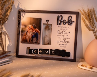 May include: A memorial picture frame with a photo of a dog and person, a small glass vial, and a black dog collar. The frame includes the name "Bob" and the text "You were my favorite hello and my hardest goodbye 2020-2025."