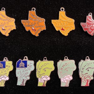 Puede incluir: Diez colgantes de plata con forma de los estados de Texas y Vermont. Los colgantes de Texas son amarillos, rojos y naranjas con los nombres de las ciudades y "Texas" escritos en ellos. Los colgantes de Vermont son verdes, azules y amarillos con las palabras "Montpelier" y "Rutland" escritas en ellos.