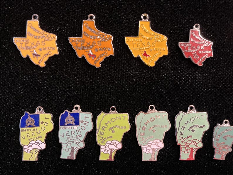 Puede incluir: Diez colgantes de plata con forma de los estados de Texas y Vermont. Los colgantes de Texas son amarillos, rojos y naranjas con los nombres de las ciudades y "Texas" escritos en ellos. Los colgantes de Vermont son verdes, azules y amarillos con las palabras "Montpelier" y "Rutland" escritas en ellos.