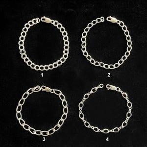 May include: Four silver-toned chain bracelets with different link designs are displayed against a black background. Each bracelet is circular, with a clasp at one end. The bracelets are numbered 1 through 4.