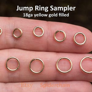 May include: A selection of yellow gold filled jump rings in various sizes. The text "Jump Ring Sampler" and "18ga yellow gold filled" are displayed at the top. The Etsy shop name "Spiderchain" is at the bottom.