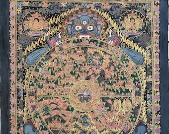Pode incluir: Uma pintura detalhada e colorida que representa a Roda da Vida, um conceito budista que representa o ciclo de nascimento, morte e renascimento. A imagem central é uma roda cercada por várias cenas da vida humana, incluindo o sofrimento, o prazer e a iluminação. A roda é segurada por uma divindade azul com múltiplos olhos e presas, simbolizando o poder do ciclo. A pintura é emoldurada por uma moldura preta com detalhes dourados.