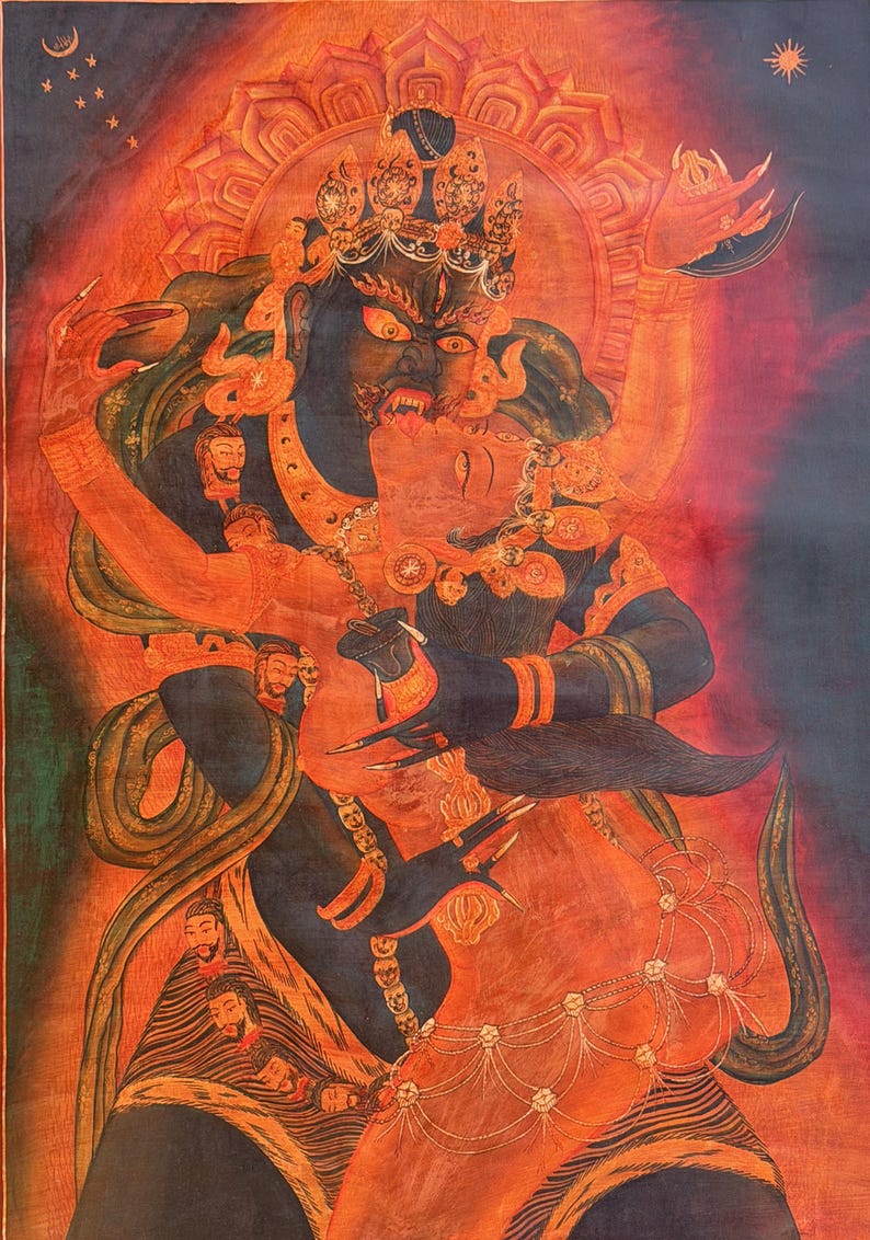May include: A detailed thangka painting depicting a dark blue deity in a fierce embrace with a red consort. The figures are adorned with ornate jewelry, crowns, and garlands of severed heads against a vibrant red and orange background with celestial symbols.