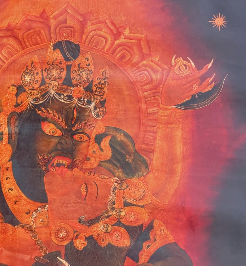 May include: A detailed painting featuring a dark blue deity with a fierce expression, wearing an ornate crown and holding a curved blade. The deity embraces a red figure against a vibrant orange and red background with a small sun symbol.