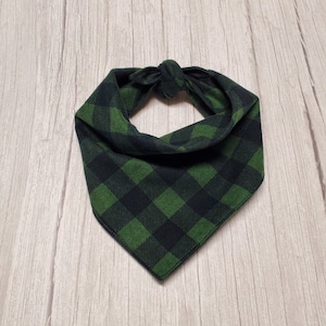 May include: A green and black plaid bandana with a knotted tie.