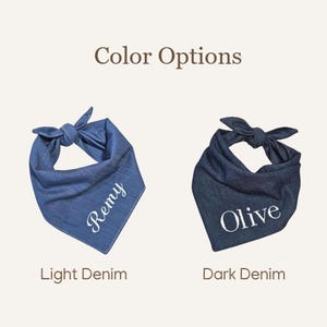 Op de afbeelding: Twee driehoekige bandana's voor huisdieren, bovenaan geknoopt. De linker bandana is lichtblauw denim met de witte tekst "Remy" in cursief schrift. De rechter bandana is donkerblauw denim met de witte tekst "Olive" in een schreeflettertype. Bovenaan staat de tekst "Color Options".