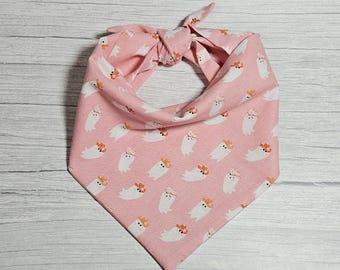 May include: A pink bandana with a pattern of white ghosts wearing orange cowboy hats.