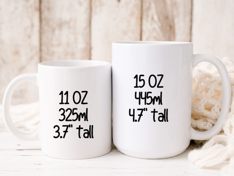 May include: Two white ceramic mugs with black text. The smaller mug is 11 oz, 325 ml, and 3.7" tall. The larger mug is 15 oz, 445 ml, and 4.7" tall.