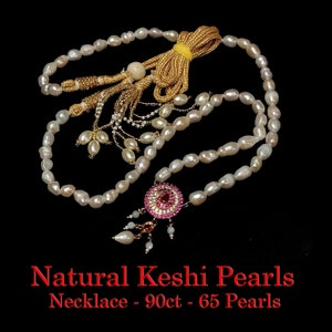 May include: A white pearl necklace with a pink and gold pendant. The necklace is 90ct and has 65 pearls. Natural Keshi Pearls Necklace - 90ct - 65 Pearls