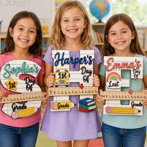 以下が含まれることがあります： 学校の節目を祝うための文字の形をした3つの木製サイン。S、H、Eの文字には罫線入りの紙の模様、Pre-Kから12までの目盛りが付いた定規のグラフィック、黄色い鉛筆、筆記体で書かれた名前がデザインされています。各サインにはスクールバス、虹、本などのアイコンが含まれています。