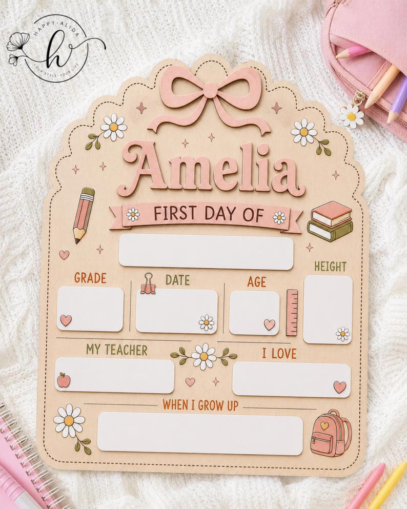 May include: A light-colored wooden sign with a scalloped edge, featuring a pink bow at the top and the name Amelia. It includes blank spaces for school details like grade, date, age, height, teacher, interests, and future goals, decorated with daisies, a pencil, books, and a backpack.
