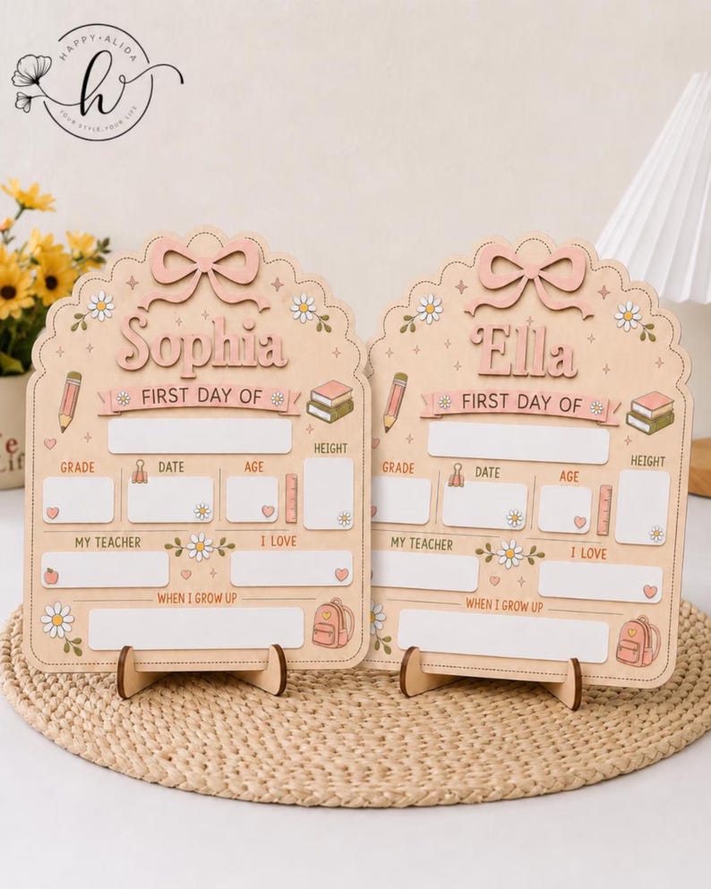 May include: Two light-colored wooden signs for the first day of school, each featuring a scalloped top with a bow, daisy accents, and illustrations of a pencil, books, and backpack. The signs are personalized with the names Sophia and Ella.