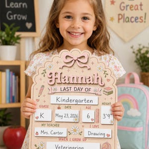 May include: A light-colored wooden sign with a scalloped top and a pink bow, featuring the name Hannah and the text Last Day Of. It includes fillable sections for Grade K, Date May 23, 2026, Age 6, Height 3'9", Teacher Mrs. Carter, I Love Drawing, and Veterinarian.