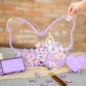 Peut inclure: Livre d'or en forme de papillon avec un cadre lilas et un centre transparent, avec le texte "Helen Quinceañera April 26, 2025." Comprend une boîte assortie et un panneau en forme de cœur avec "Please sign my guest book."