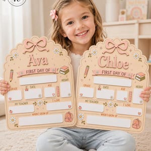 May include: Two arched wooden signs for the first day of school, featuring a light wood finish with pink accents. Each sign displays a name, Ava or Chloe, with sections for grade, date, age, height, teacher, interests, and future career goals.