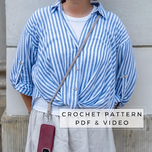 May include: A woman wearing a blue and white striped shirt with a beige phone strap and a burgundy phone case. The text "CROCHET PATTERN PDF & VIDEO" is on a white rectangle in the lower center of the image.
