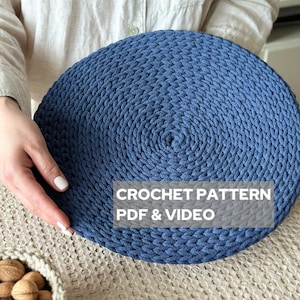 Puede incluir: Un posavasos redondo de crochet azul con un patrón texturizado. El texto "CROCHET PATTERN PDF & VIDEO" está impreso en el posavasos.
