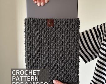 May include: Grey crocheted laptop sleeve with a brown leather button closure. CROCHET PATTERN PDF & VIDEO text is visible at the bottom of the image.