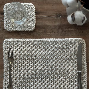May include: A set of three ceramic mugs with a speckled, matte finish. The mugs are in shades of cream, light gray, and dark gray. Each mug has a simple, minimalist design and a rounded handle.