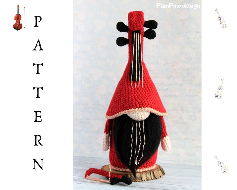 May include: A handmade red and black crochet gnome shaped like a violin. The gnome has a long black beard, a red hat, and white accents. A small wooden bow rests in front of the gnome.