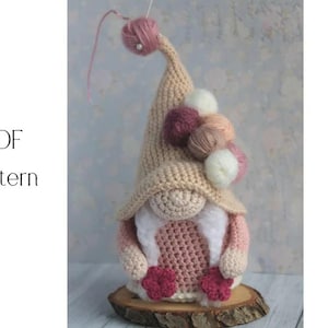 May include: A handmade crochet gnome doll with a long beige hat and a white beard. The gnome has a pink body and is decorated with yarn balls in various colors. The text "PDF Pattern" is visible.