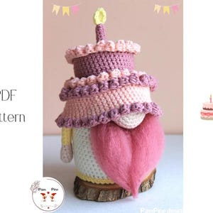 Könnte beinhalten: Ein gehäkelter Wichtel in Form einer Geburtstagstorte mit rosa und lila Garnschichten. Er hat einen rosa, herzförmigen Bart und eine gelbe Kerze. Das Bild enthält den Text "PDF Pattern".