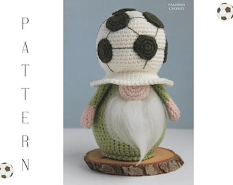 May include: A handmade crochet gnome with a soccer ball hat. The gnome has a white beard, a pink nose, and green and pink clothing. It is displayed on a wooden slice. The word "PATTERN" is written vertically on the left.
