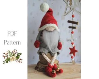 May include: A handmade crochet gnome doll with a red hat, gray sweater, and long white beard. The gnome has red mittens and shoes with bells. The doll is sitting on a wooden surface. A decorative star and bead garland is in the background.