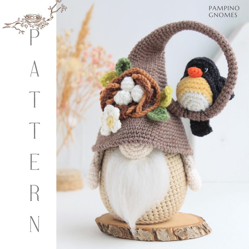 Puede incluir: Un gnomo de ganchillo hecho a mano con una larga barba blanca, que lleva un sombrero marr&oacute;n adornado con un nido, flores y un pajarito. El gnomo est&aacute; sobre una base de madera. La palabra "PATTERN" se muestra verticalmente a la izquierda y "PAMPINO GNOMES" a la derecha.
