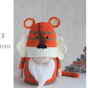 May include: A handmade crochet tiger doll with orange and brown stripes, white accents, and a long white beard. The doll has small ears and a black nose. The text "PDF Pattern" is visible in the image.