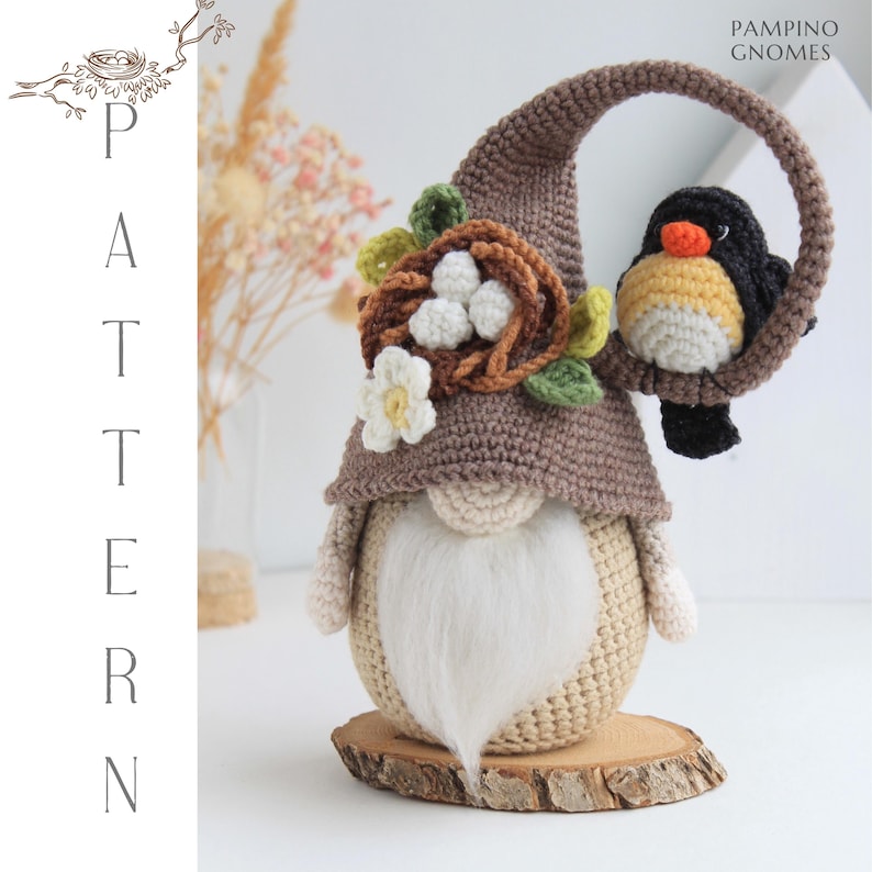Puede incluir: Un gnomo de ganchillo hecho a mano con un gorro puntiagudo marr&oacute;n, barba blanca y un peque&ntilde;o p&aacute;jaro posado en su sombrero. El gnomo est&aacute; decorado con un nido, huevos y flores. La palabra "PATTERN" se muestra verticalmente a la izquierda.
