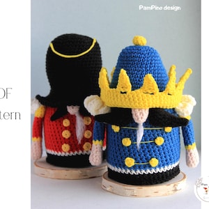 Pode incluir: Duas figuras de crochê, uma com chapéu preto e jaqueta vermelha, a outra com jaqueta azul e coroa amarela. As figuras estão em bases de madeira. A imagem inclui o texto "PDF Pattern".