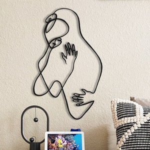 Arte de pared minimalista de pareja abrazándose en metal: dibujo lineal moderno