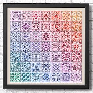 K&ouml;nnte beinhalten: Ein Kreuzstichmuster mit einem Regenbogen aus bunten geometrischen Mustern. Das Muster ist in einem schwarzen Rahmen gerahmt und wird vor einer wei&szlig;en Backsteinwand gezeigt.