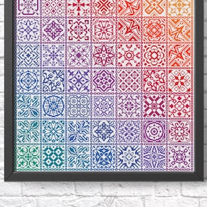 K&ouml;nnte beinhalten: Ein gerahmtes Kreuzstichmuster mit einem Regenbogen-Farbverlauf von geometrischen Designs. Das Muster besteht aus 36 einzelnen Quadraten, jedes mit einem anderen Design. Der Rahmen ist schwarz und der Hintergrund ist wei&szlig;.