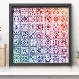 K&ouml;nnte beinhalten: Ein Kreuzstichmuster mit einem farbenfrohen, schillernden Patchwork-Design. Das Muster ist gerahmt und auf einem wei&szlig;en Regal mit einer Ziegelwand im Hintergrund ausgestellt. Der Text "IRIDESCENT PATCHWORK" ist unter dem Rahmen zu sehen.